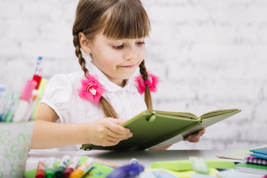 urocza-dziewczyna-cieszaca-sie-czytaniem-podrecznikow